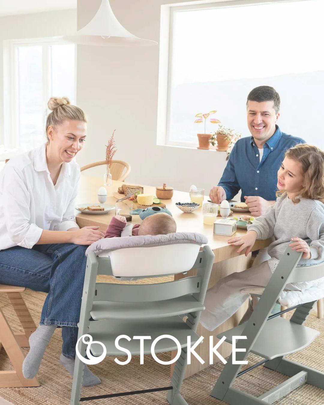 Trona Stokke Tripp Trapp en uso con una familia, configurada como trona para bebé y como silla evolutiva para niños mayores